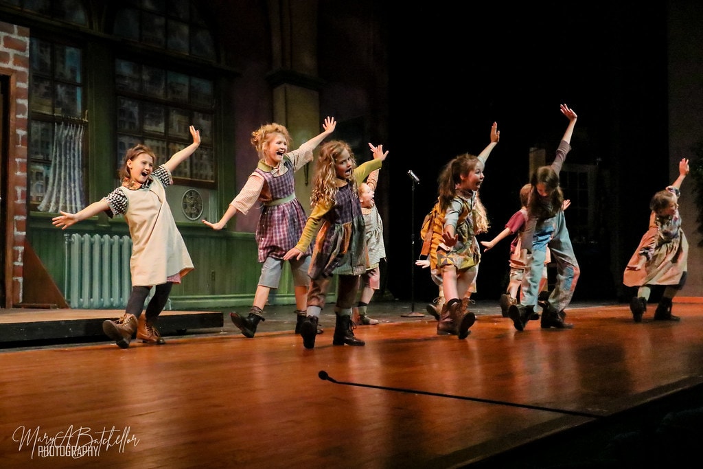 Annie — eight orphan girls skip across the full stage before the Central Park backdrop