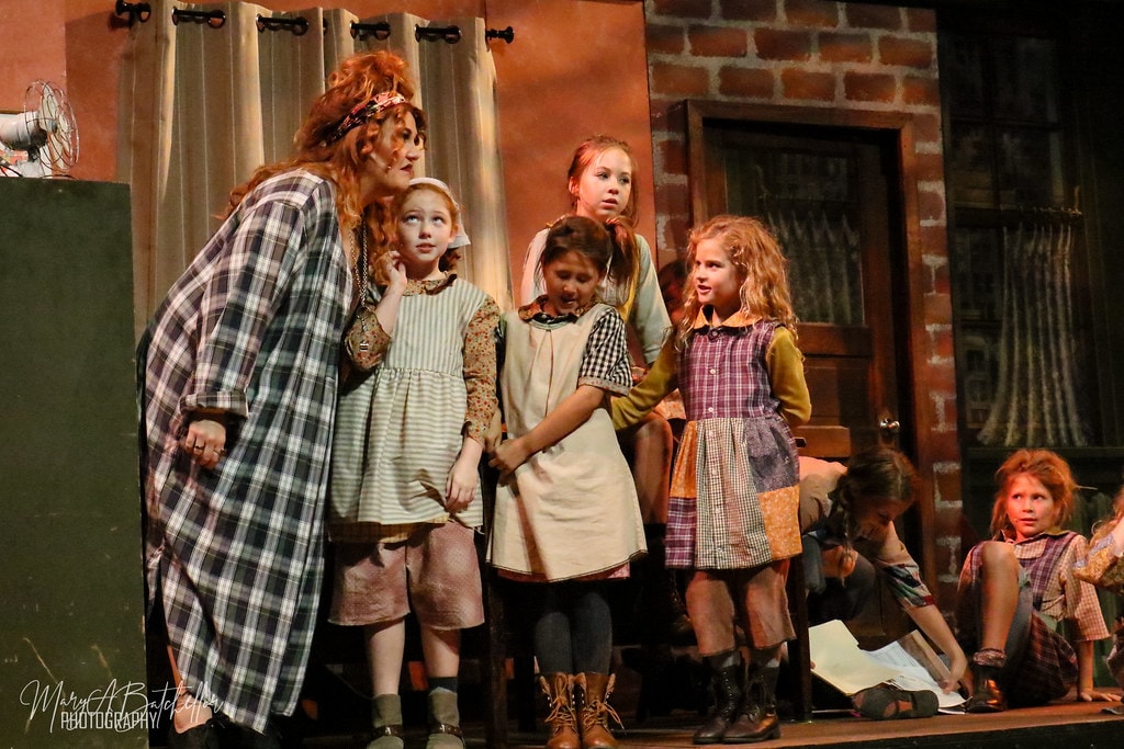 Annie — Miss Hannigan in a plaid nightgown looms over five nervous orphan girls