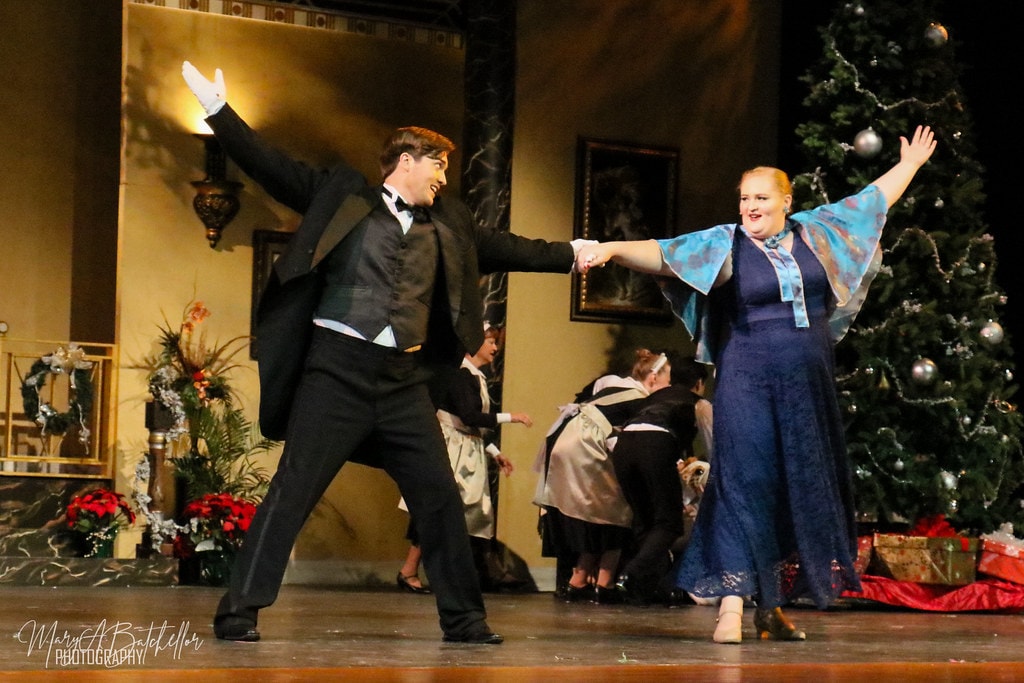 Annie — Oliver Warbucks and a woman in a blue gown dance before the decorated Christmas tree
