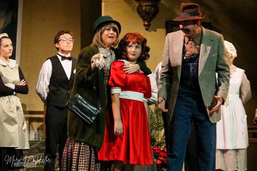 Annie — a woman clutches Annie as Rooster leans in menacingly in the confrontation scene