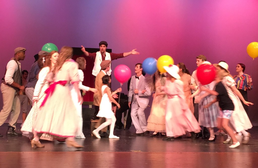 Colorful balloon ensemble scene with Billy directing — Carousel