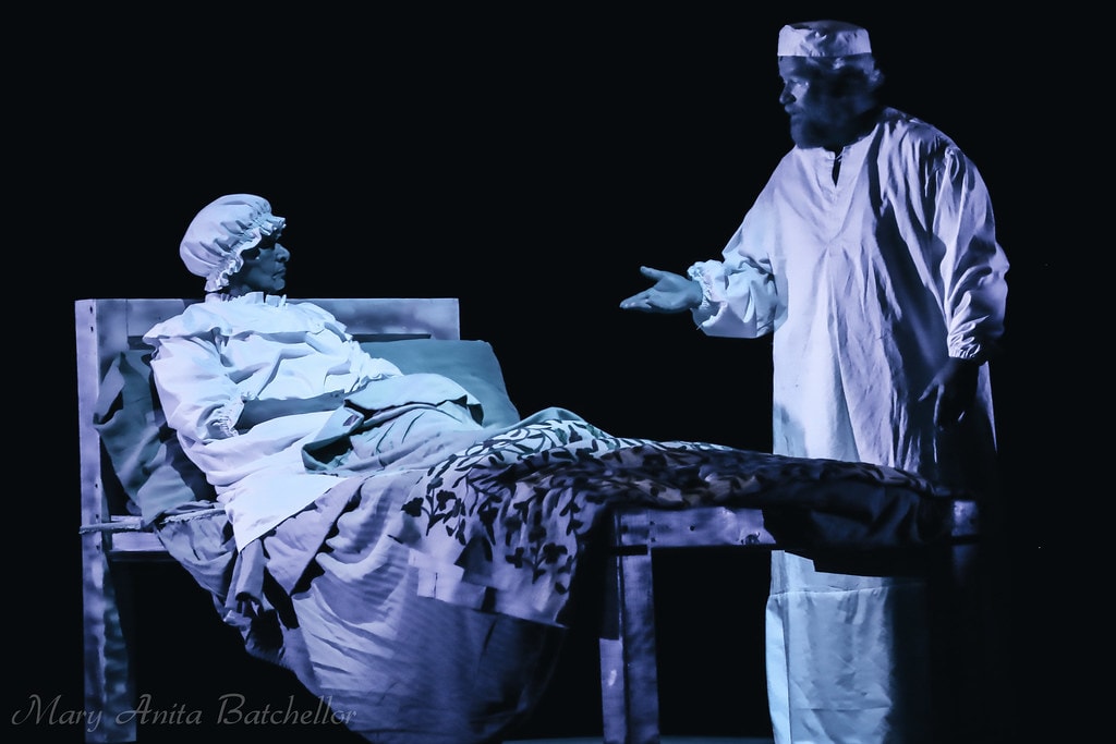 Fiddler on the Roof — Tevye in a white nightgown gestures toward Golde lying in bed in the eerie blue-lit dream sequence