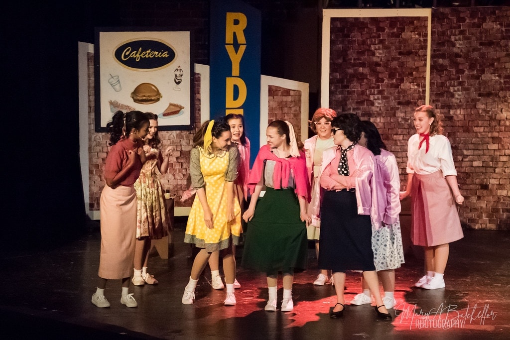 Grease — Sandy and Pink Ladies meeting at Rydell cafeteria set