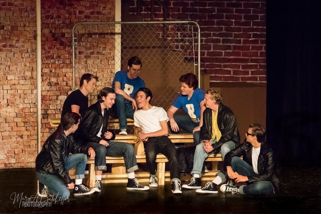 Grease — T-Birds surrounding Danny on knees in intense confrontation