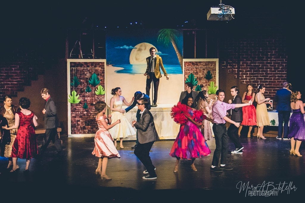Grease — full cast dancing at beach party with Teen Angel singing