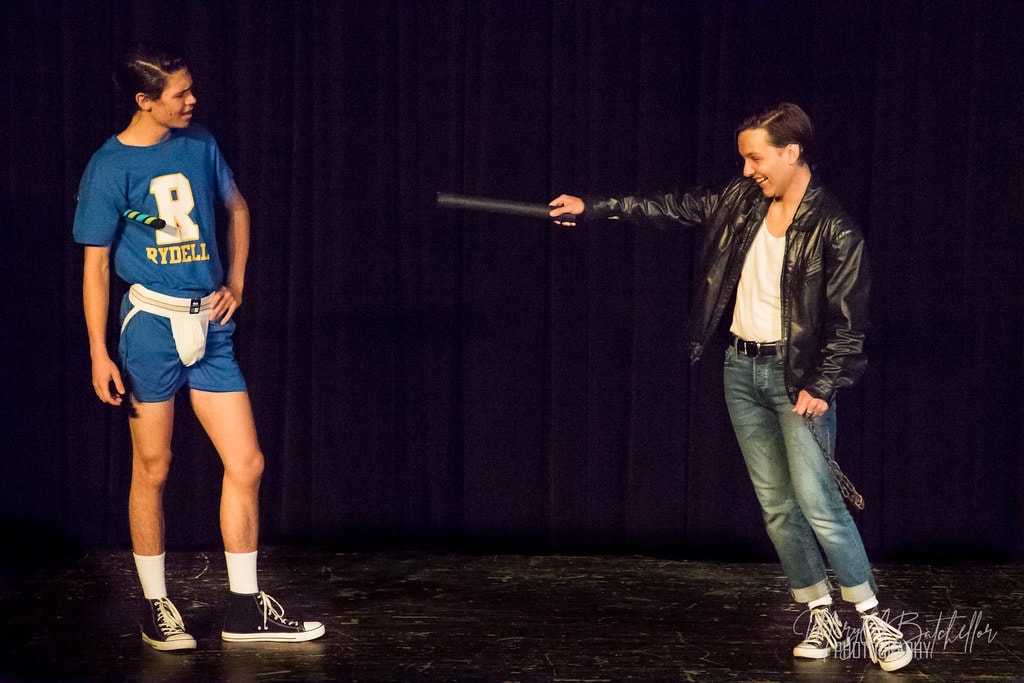 Grease — Danny in Rydell athletic uniform facing off with T-Bird