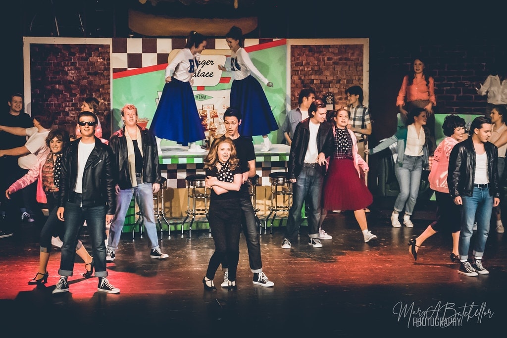 Grease — wide shot of full cast dancing at Burger Palace