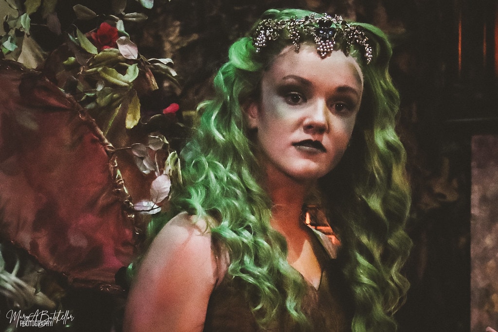 Into the Woods — the Witch in a dramatic close-up portrait with green hair, jeweled crown, and fairy wings