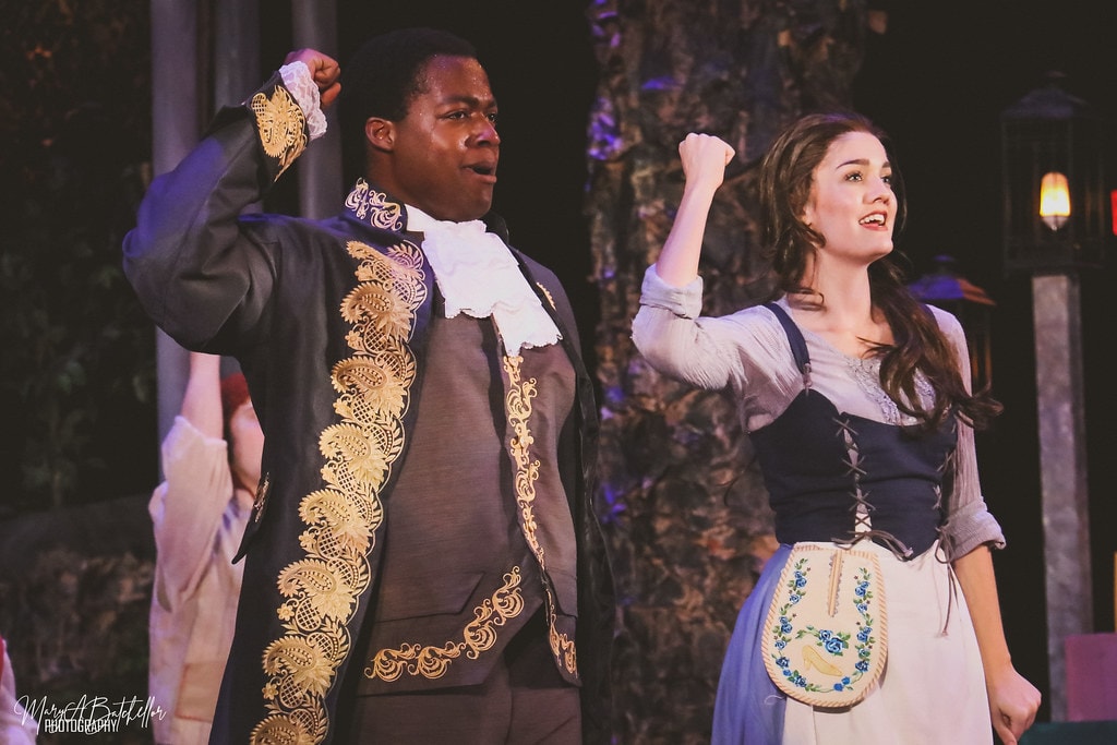 Into the Woods — Cinderella's Prince and the Baker's Wife raise their fists in triumph in the enchanted forest