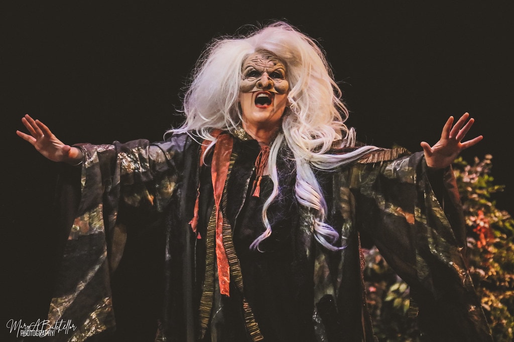 Into the Woods — the Baker in a red vest confronts Jack in the dark enchanted forest