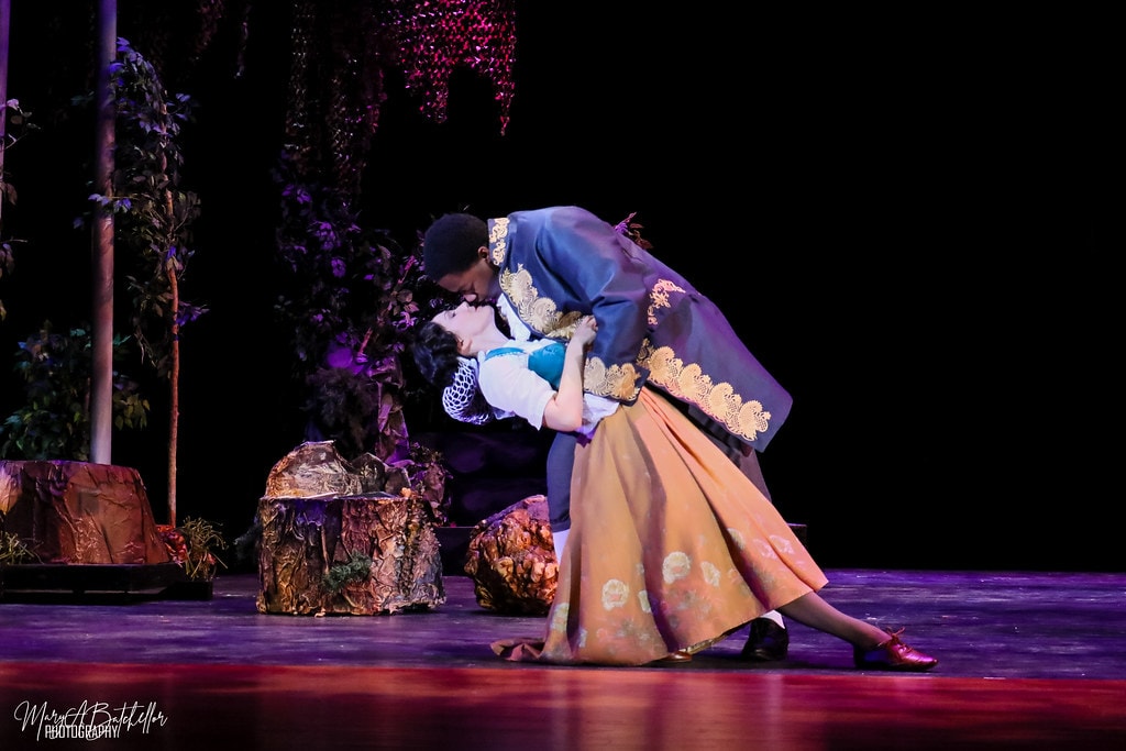 Into the Woods — Cinderella's Prince dips Cinderella in a sweeping romantic embrace in the purple-lit forest