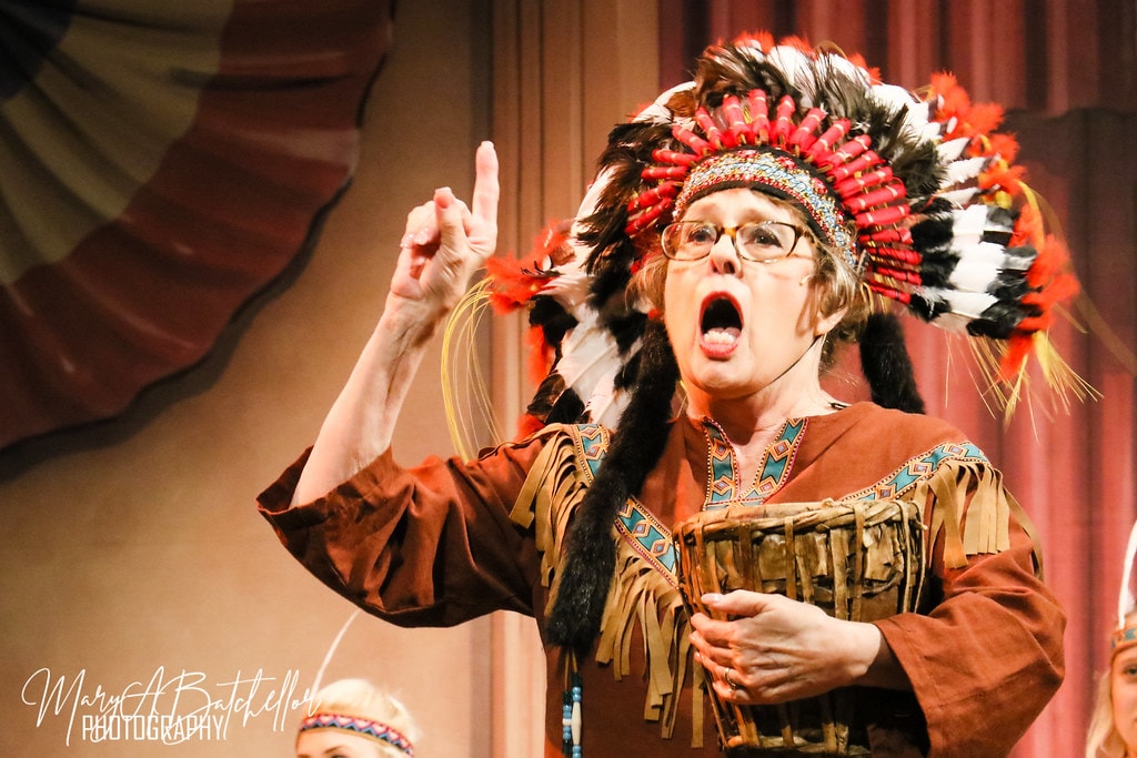 The Music Man — the Chief in a feathered headdress belts a solo