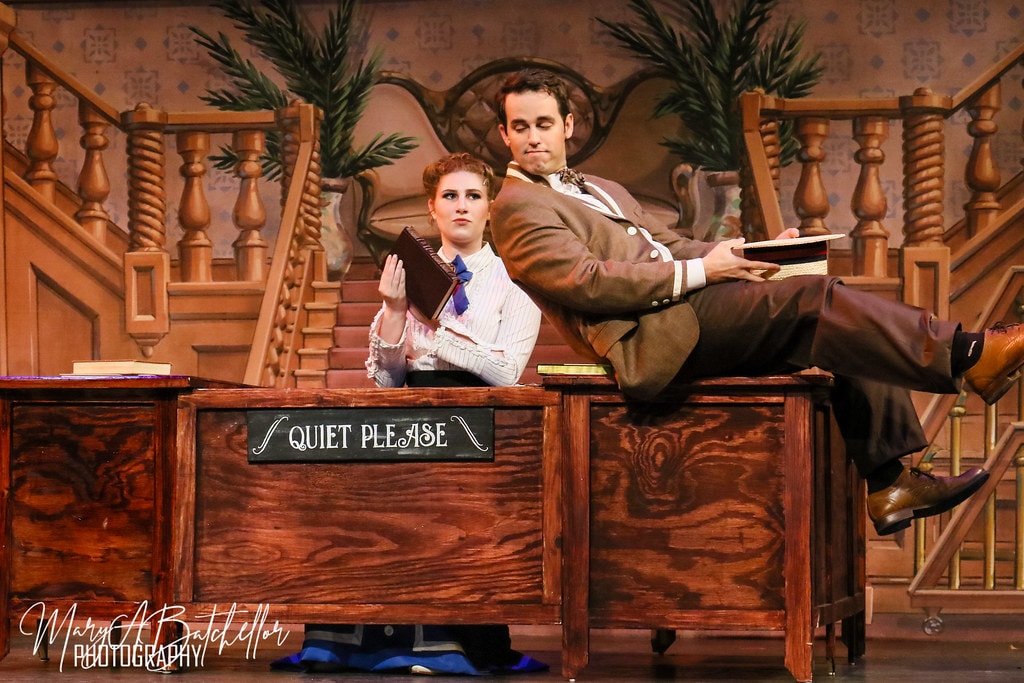 The Music Man — Marian at the library desk as Harold Hill reclines on it