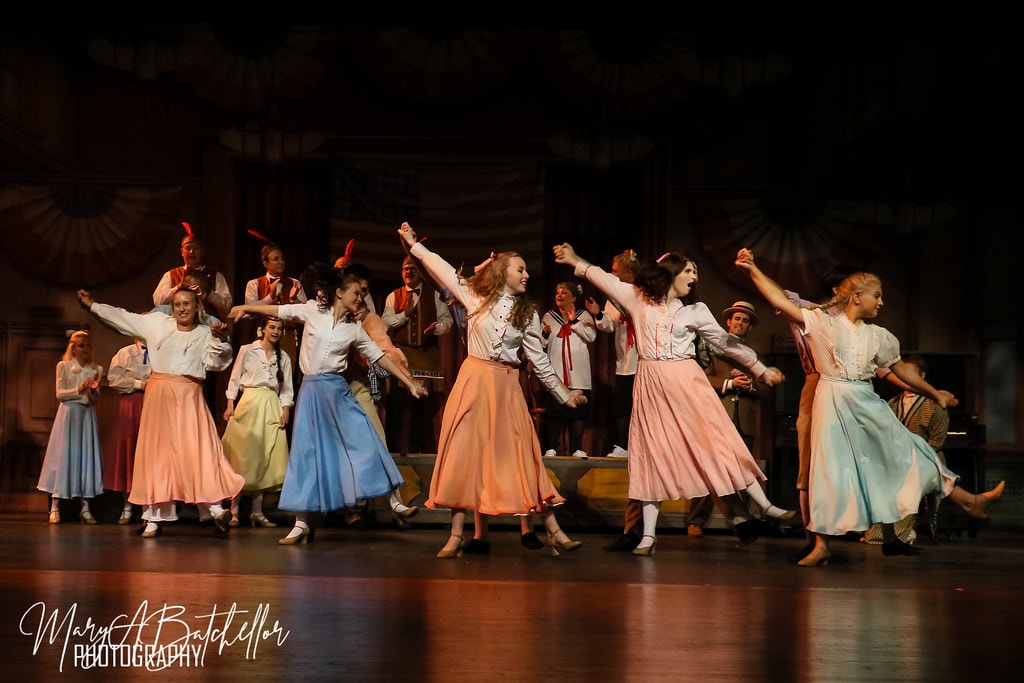 The Music Man — women in pastel skirts raise their arms in a wide dance formation