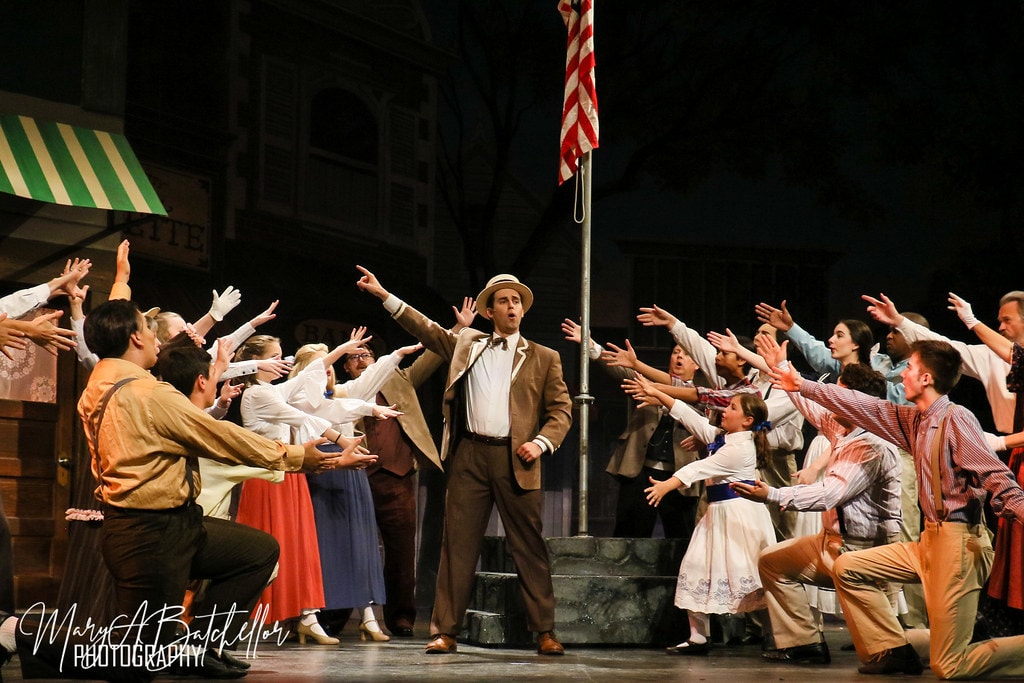 The Music Man — Harold Hill center stage with arms outstretched