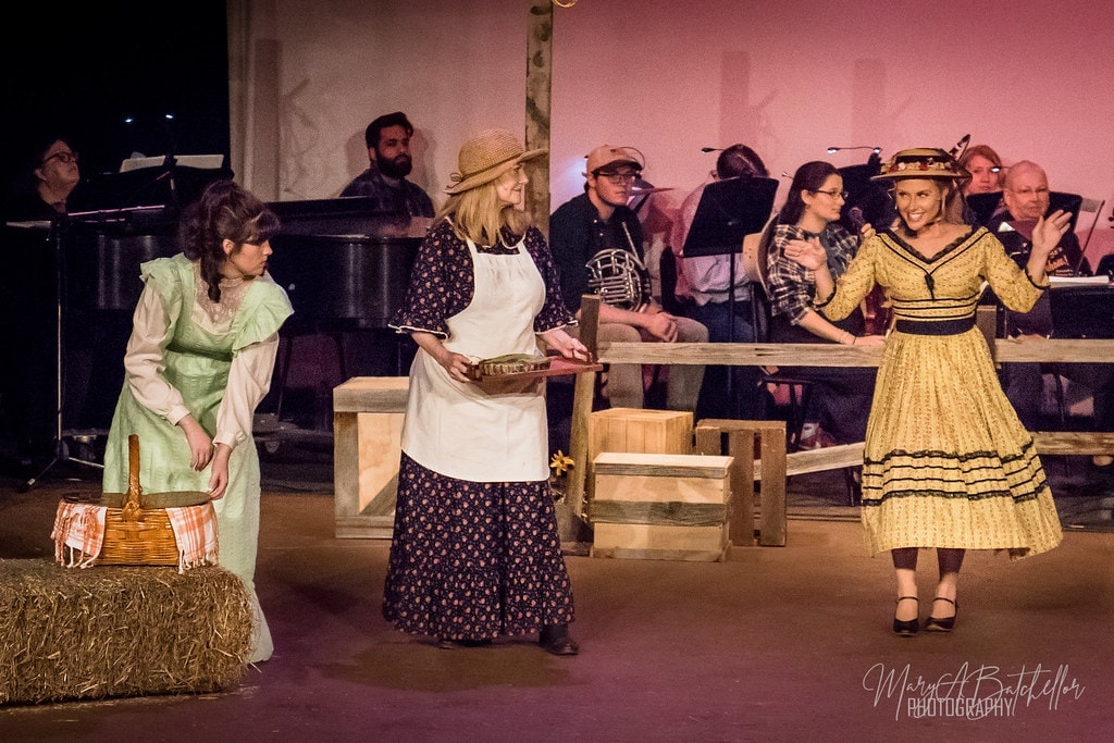 Oklahoma! — Ali Hakim and cowboys under purple lights