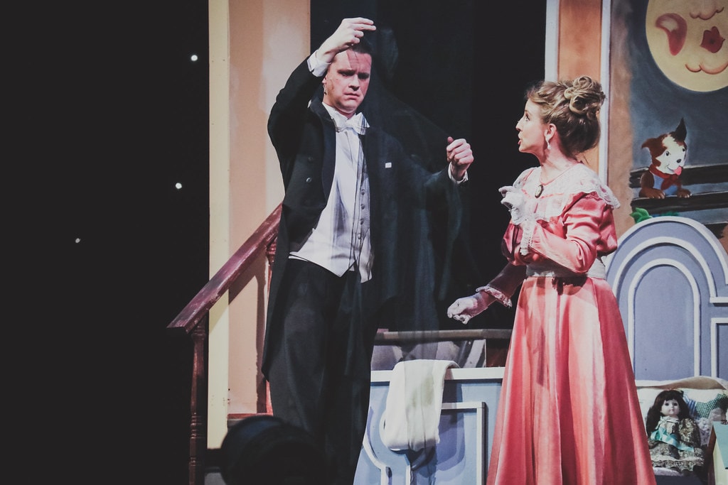 Peter Pan — Mr. and Mrs. Darling face each other in the nursery set with the moon and dog painted on the wall