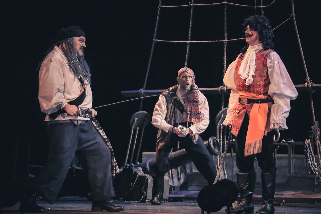 Peter Pan — Captain Hook and two pirates in a tense standoff on the dark ship deck set
