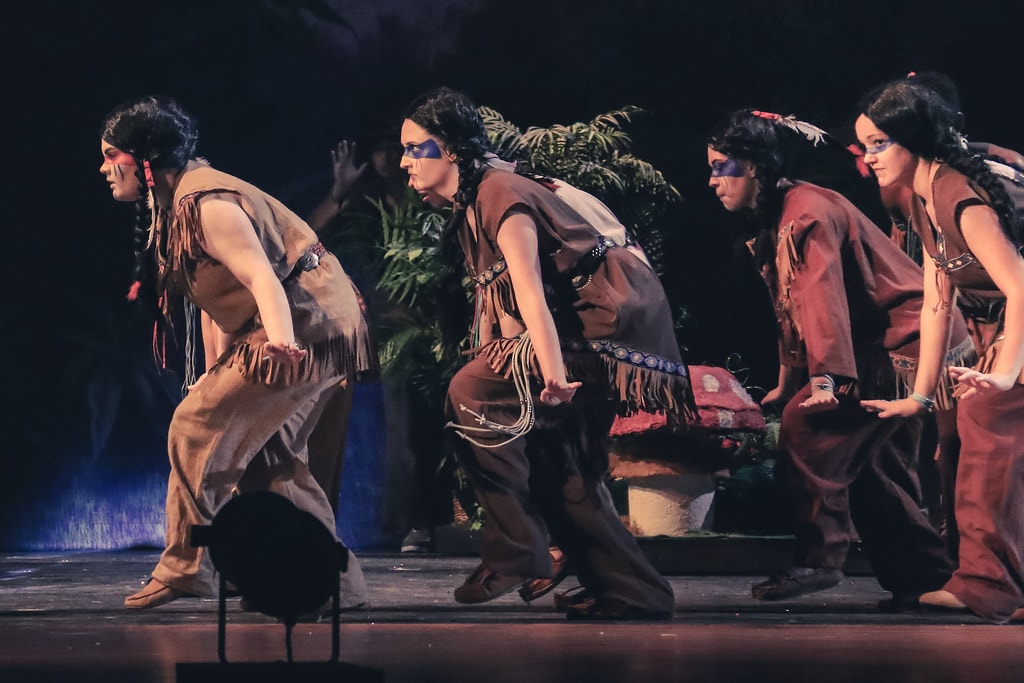 Peter Pan — four performers in Native American costumes creep out in a dramatic line before the jungle backdrop