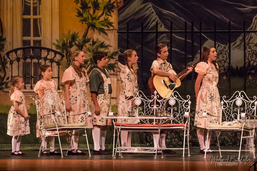 The Sound of Music — all seven von Trapp children in floral costumes singing