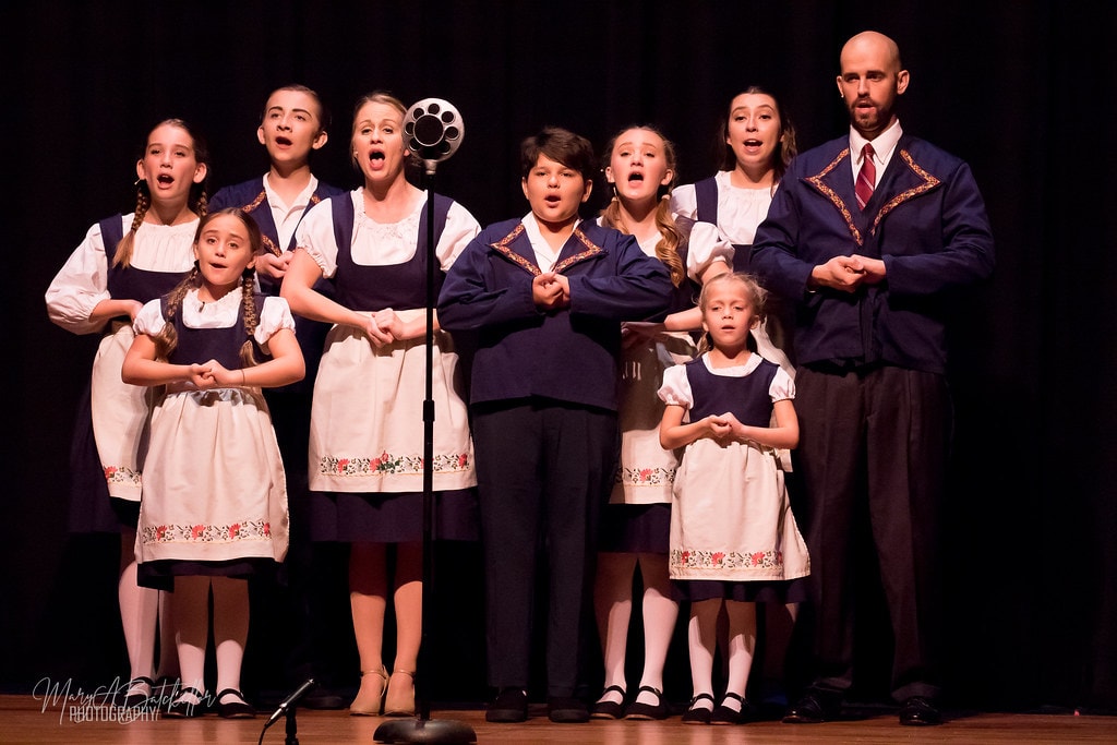 The Sound of Music — Captain von Trapp and von Trapp children singing at vintage microphone