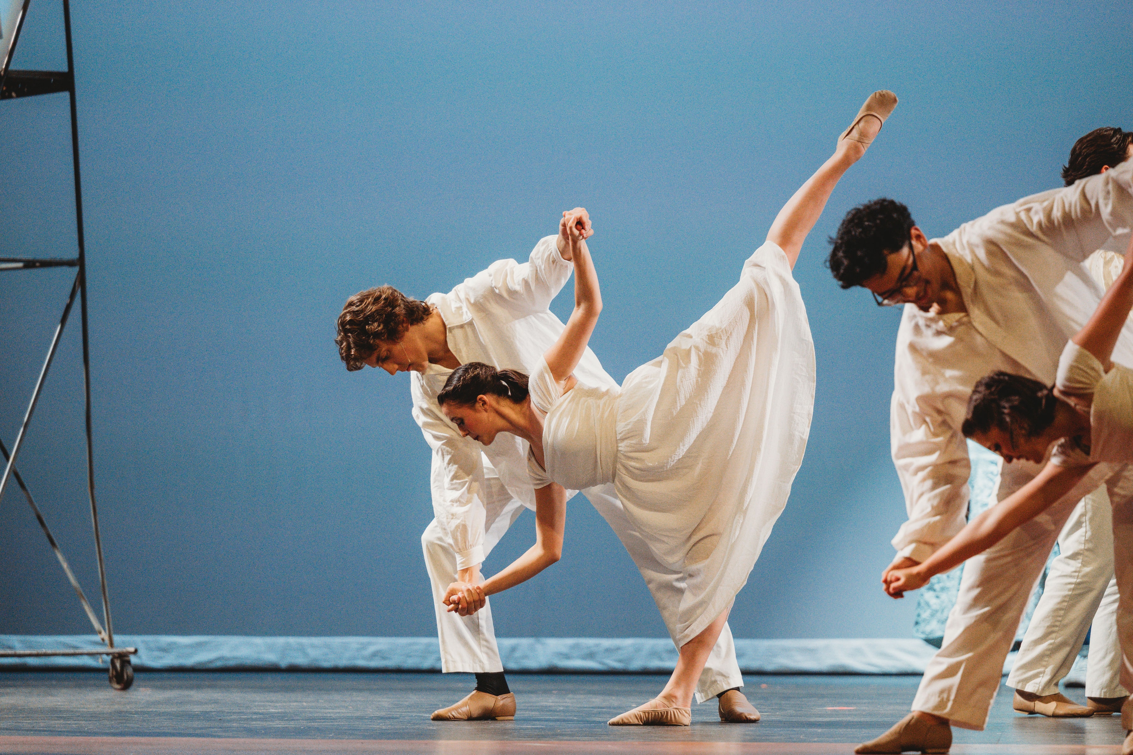West Side Story 2026 - dancers in white performing a dramatic dip on blue backdrop
