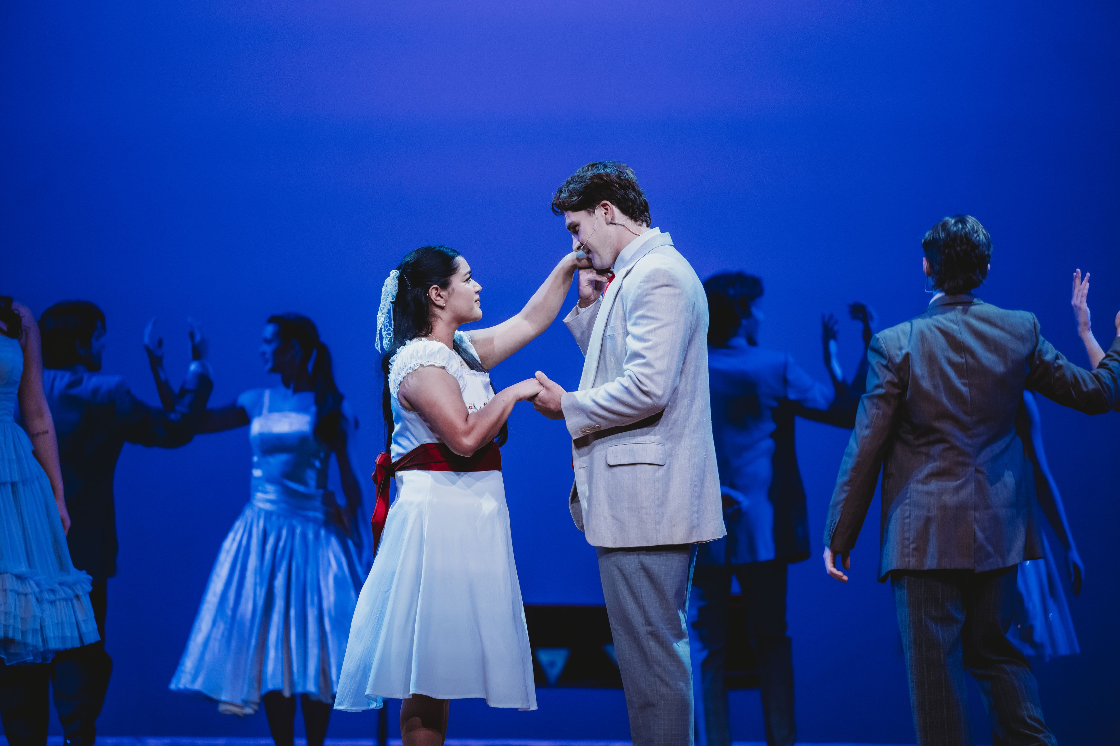 West Side Story 2026 - Maria and Tony meeting at the dance with ensemble in blue light